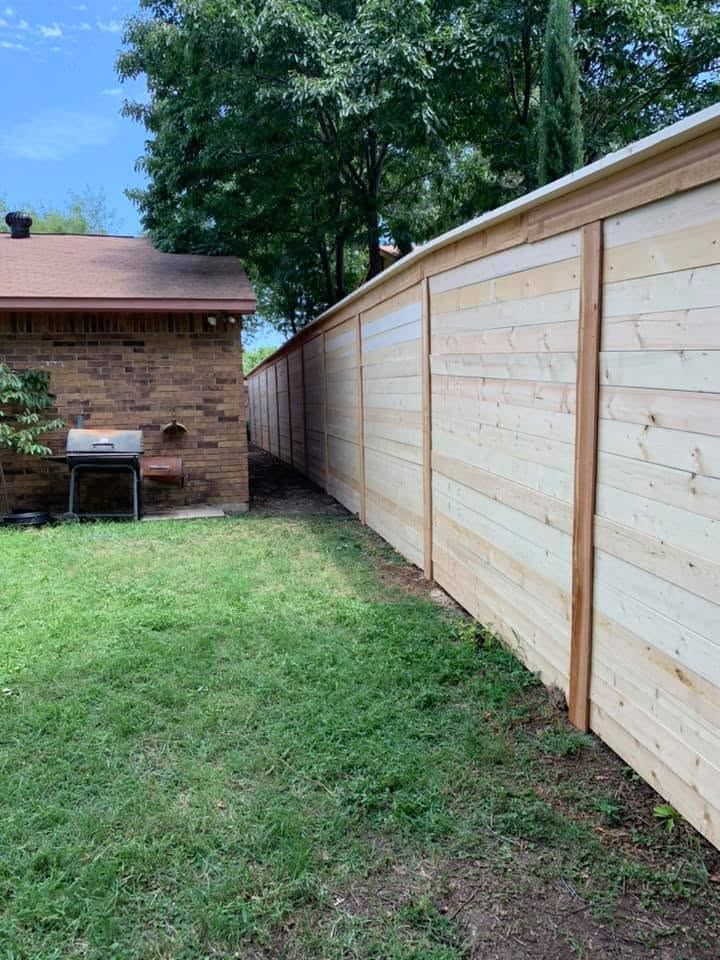 Horizontal-plank wood fence beside a brick house