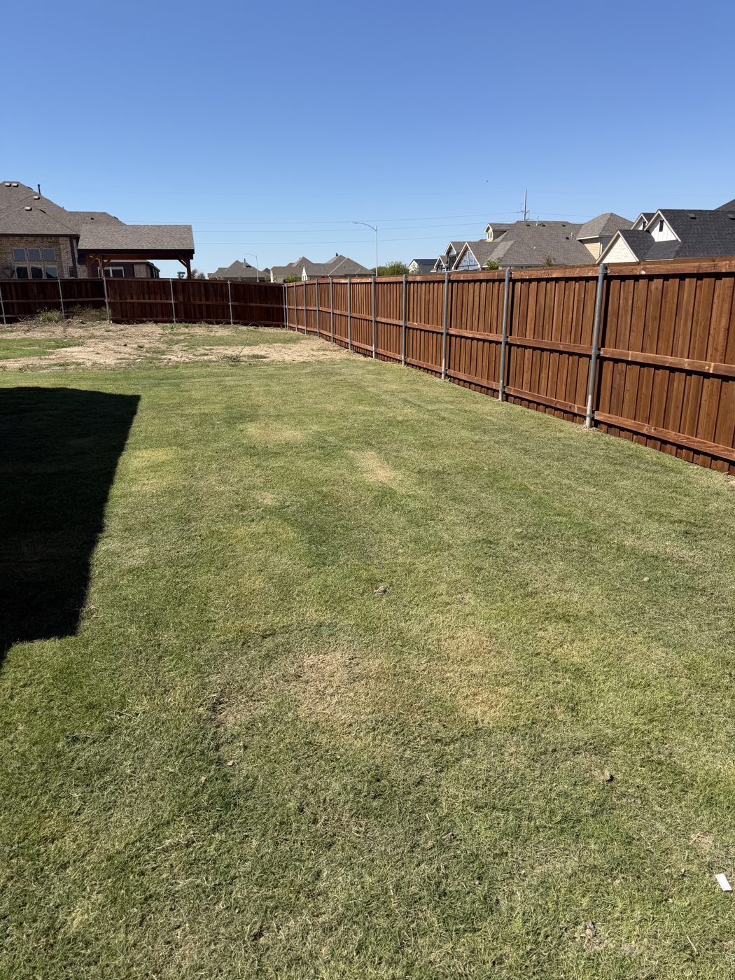 Wood fence corner with metal posts in a backyard