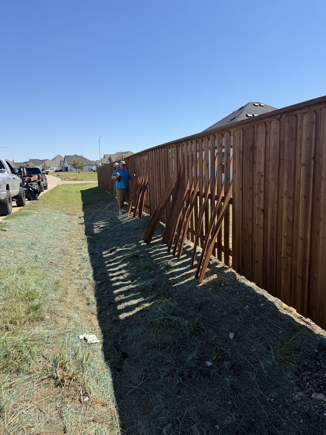 Crew member installing wood fence post bracing
