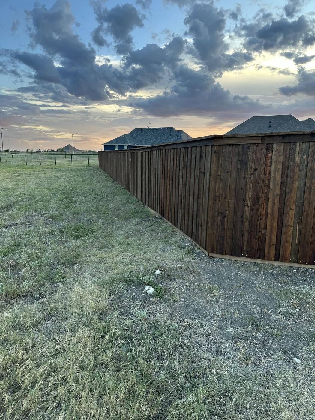 Long stained wood fence line at dusk