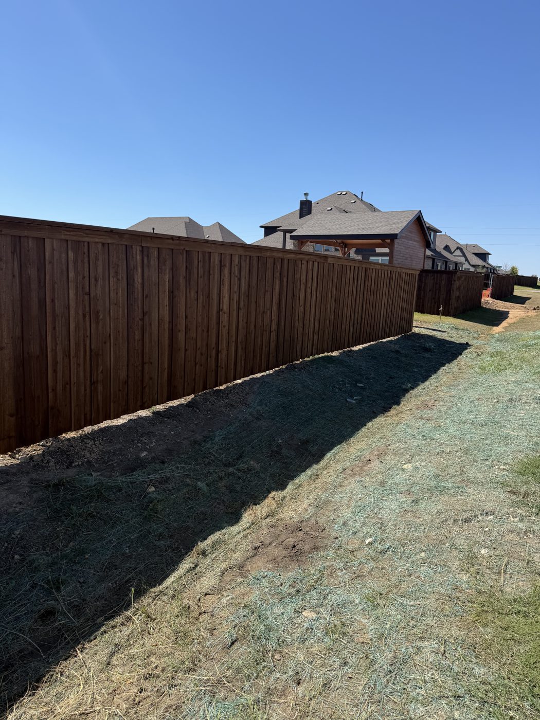 Long wood privacy fence line at a new construction home