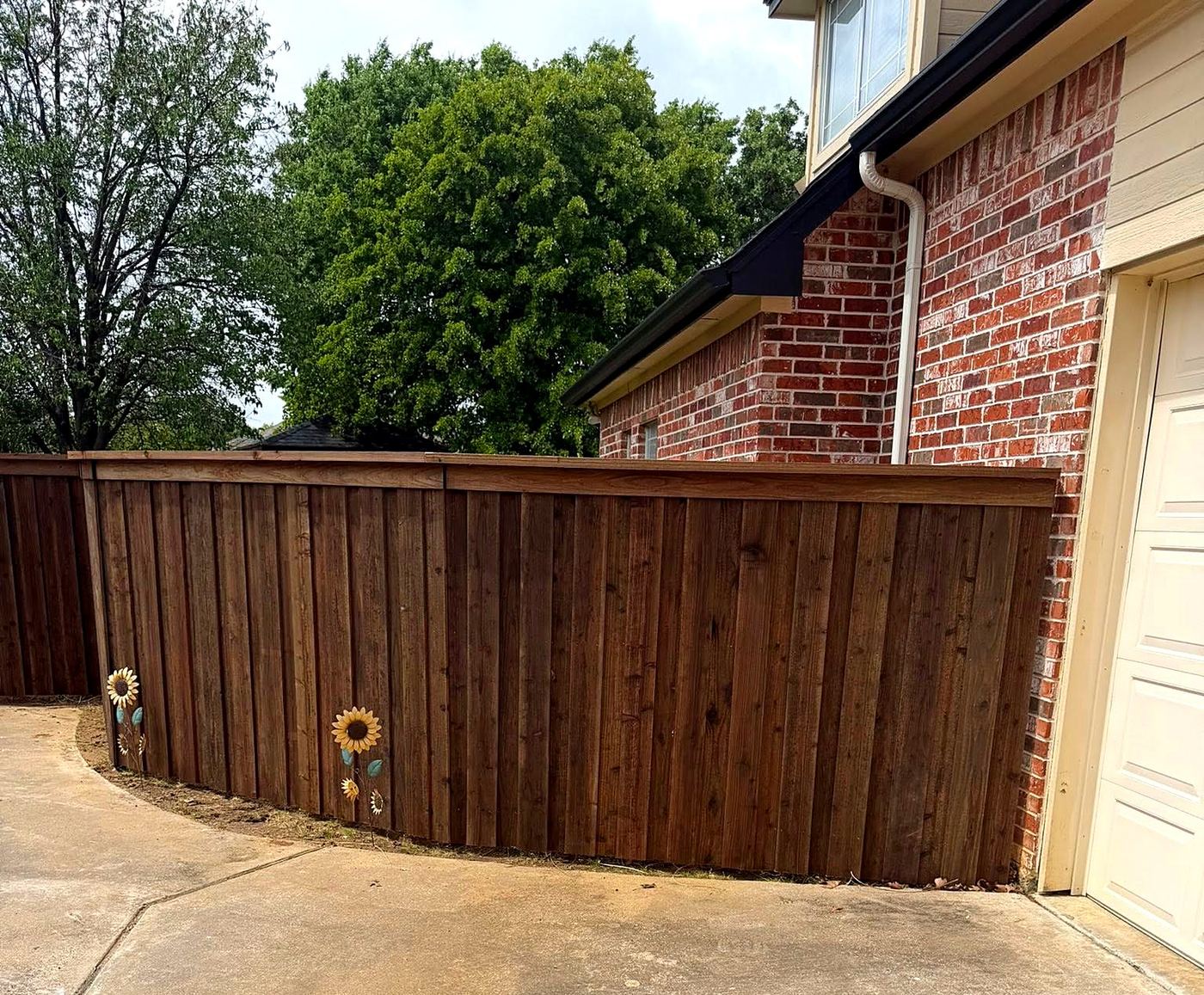 Wood privacy fence along a curved driveway