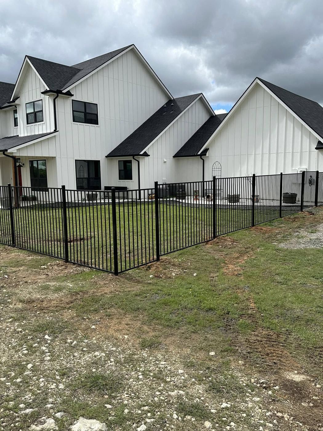 Black ornamental aluminum fence around a new home