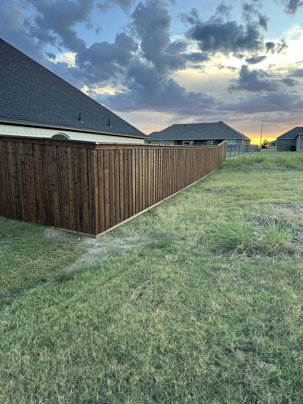 Stained wood privacy fence installed by Circle H Fence Co.